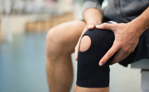 Man wearing knee brace, cropped