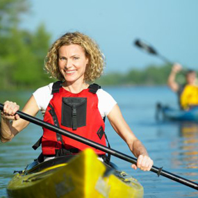 Mature woman paddling in kayak, portrait. close-up